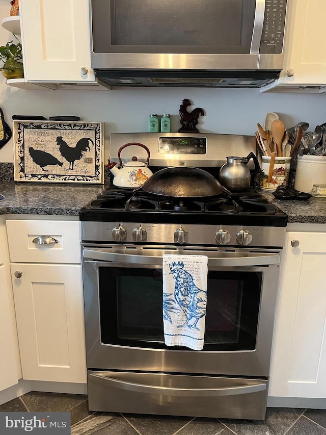 kitchen with white cabinetry, appliances with stainless steel finishes, and open shelves