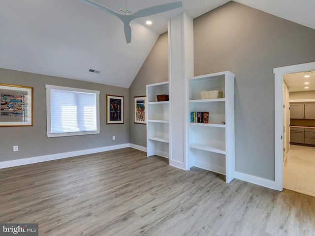 unfurnished living room featuring lofted ceiling, visible vents, baseboards, and wood finished floors