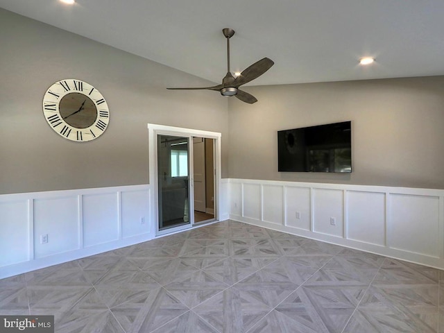 empty room featuring recessed lighting, a decorative wall, a ceiling fan, wainscoting, and vaulted ceiling