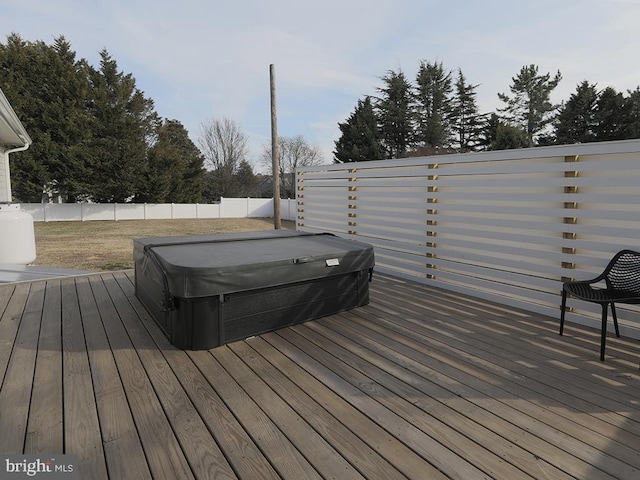 deck featuring a covered hot tub and a fenced backyard