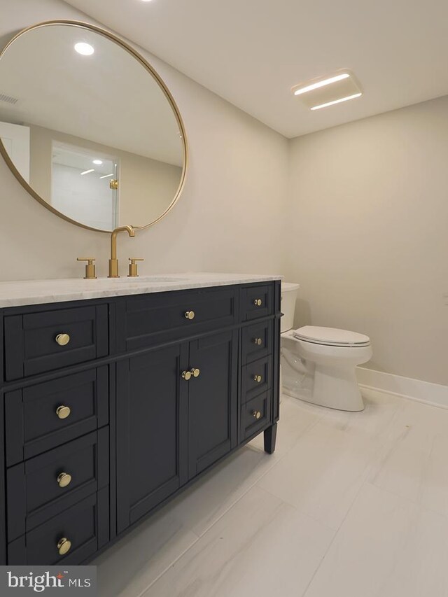 bathroom with vanity, toilet, and baseboards