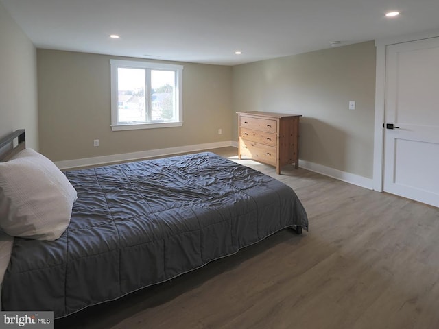 bedroom featuring baseboards, wood finished floors, and recessed lighting