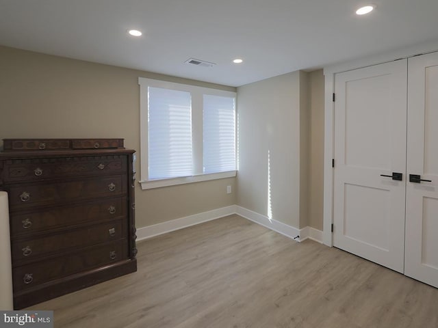 unfurnished bedroom featuring light wood finished floors, recessed lighting, a closet, visible vents, and baseboards