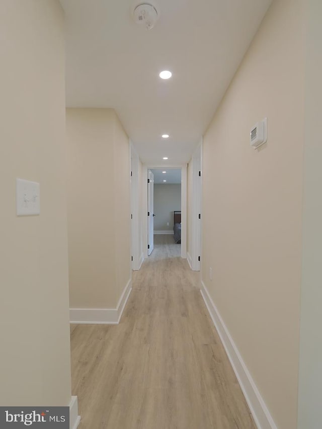 hall with recessed lighting, baseboards, and light wood finished floors