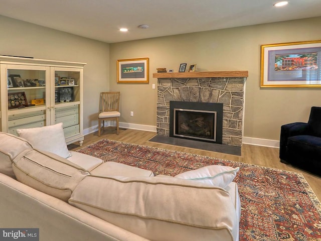 living room featuring recessed lighting, a fireplace, wood finished floors, and baseboards