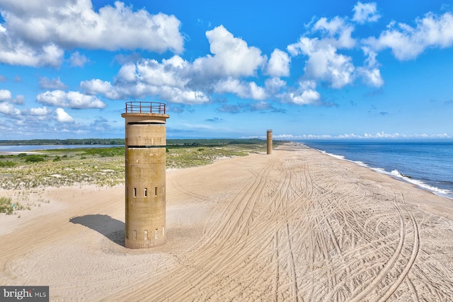 view of property's community featuring a water view and a beach view