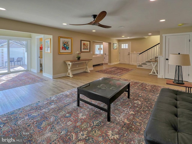 living area with baseboards, stairway, wood finished floors, and recessed lighting