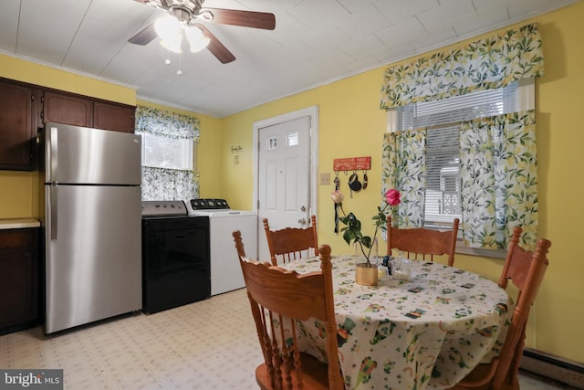 dining area featuring crown molding, light floors, a baseboard radiator, a ceiling fan, and washer and dryer