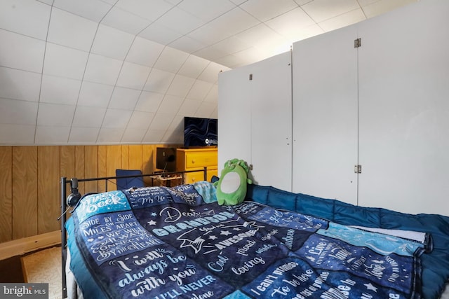 bedroom with wood walls and vaulted ceiling