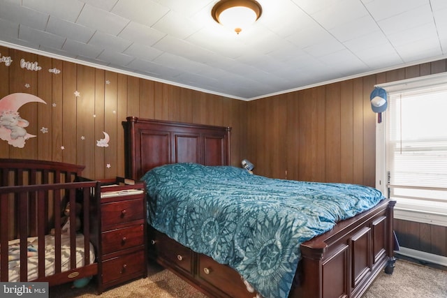 bedroom featuring wooden walls, multiple windows, and light colored carpet