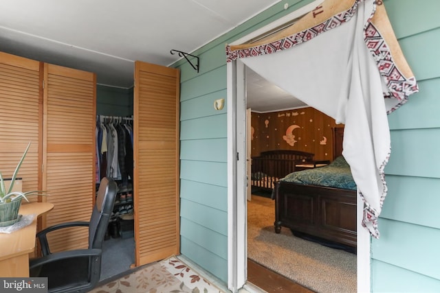 carpeted home office with wood walls