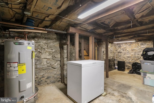 unfinished below grade area with water heater and fridge