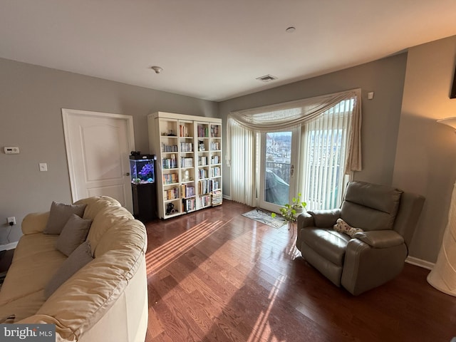 living area with visible vents and wood finished floors