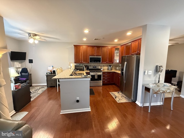 kitchen featuring dark wood-style floors, a peninsula, appliances with stainless steel finishes, and glass insert cabinets