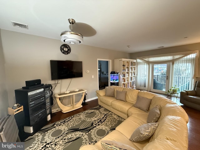 living area featuring baseboards, visible vents, and wood finished floors