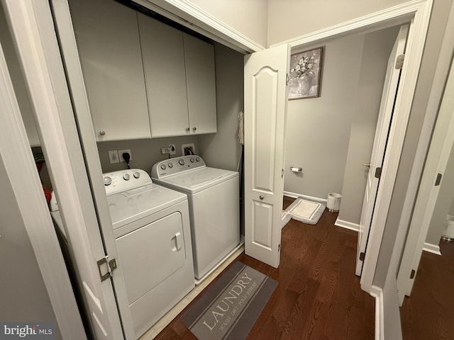 clothes washing area with dark wood-style flooring, cabinet space, baseboards, and separate washer and dryer