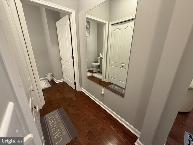 bathroom with toilet, baseboards, and wood finished floors