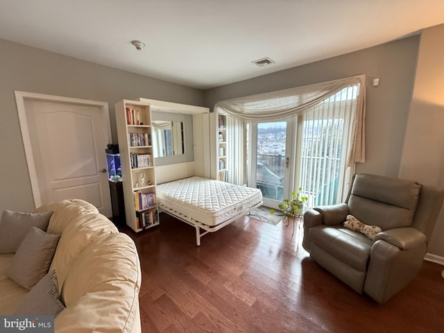 bedroom with access to exterior, visible vents, and wood finished floors