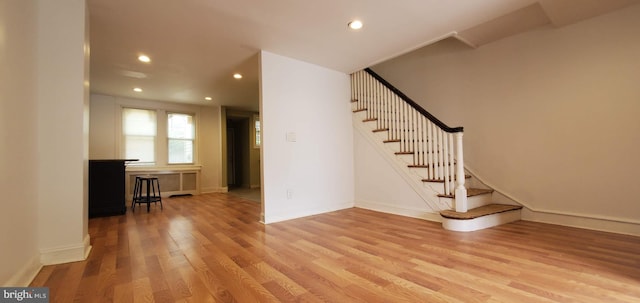 interior space featuring baseboards, light wood finished floors, stairway, and recessed lighting