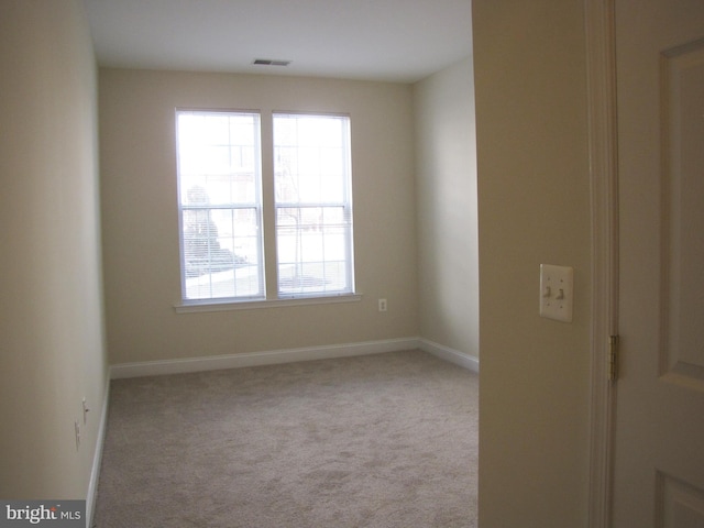 empty room with baseboards, visible vents, and carpet flooring