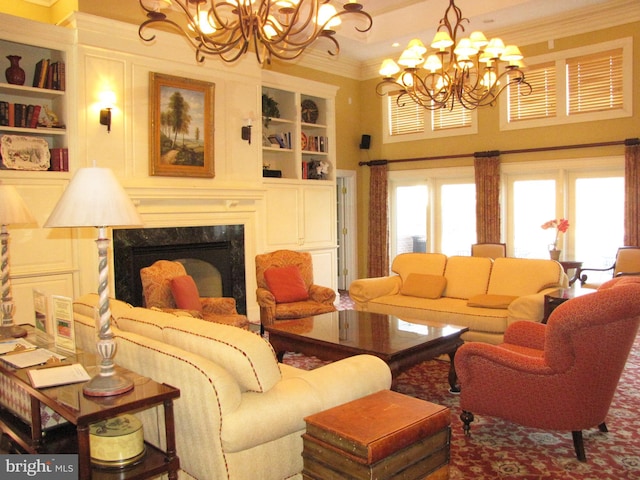 living area with built in shelves, ornamental molding, a chandelier, and a premium fireplace