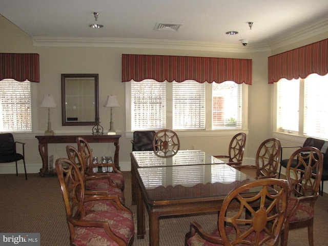 carpeted dining area with baseboards, visible vents, and ornamental molding