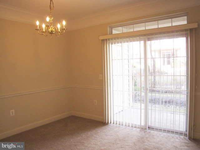 spare room with carpet floors, ornamental molding, a wealth of natural light, and a notable chandelier