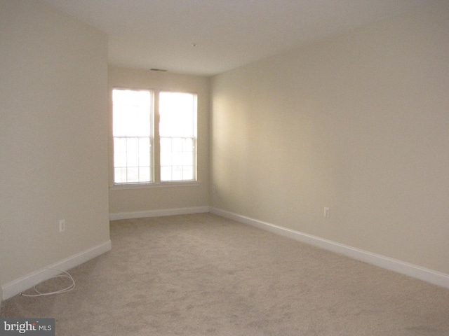 empty room with carpet and baseboards