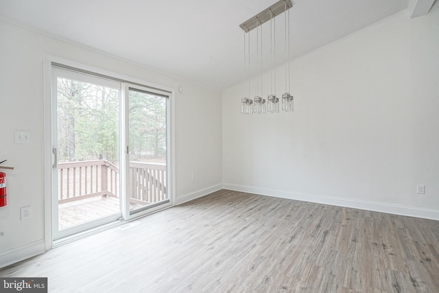 empty room with lofted ceiling, baseboards, and wood finished floors