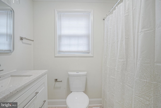 bathroom with toilet, baseboards, and vanity