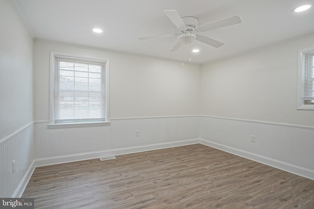 empty room with a wainscoted wall, visible vents, wood finished floors, and recessed lighting