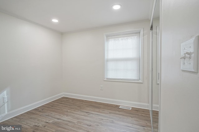 spare room with baseboards, wood finished floors, and recessed lighting