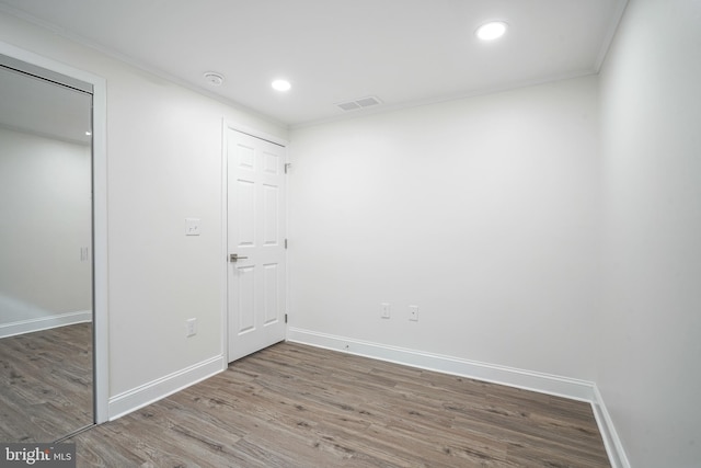 spare room with baseboards, visible vents, and wood finished floors