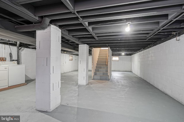 unfinished basement featuring stairs and washing machine and clothes dryer