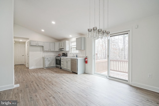 kitchen featuring appliances with stainless steel finishes, gray cabinets, light countertops, and a sink