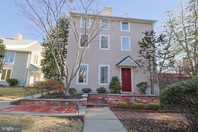 view of property with a chimney and stucco siding