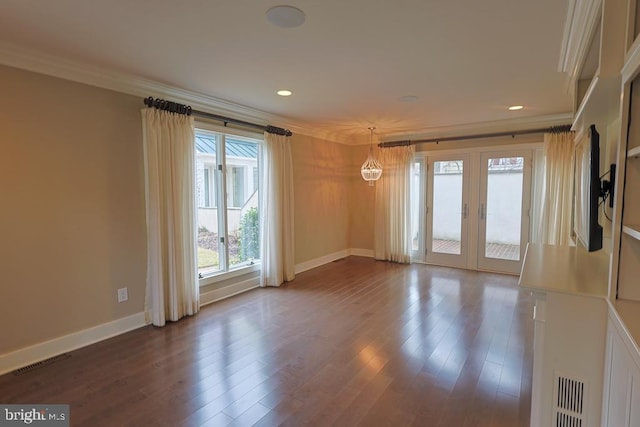 empty room with visible vents, baseboards, dark wood-style flooring, french doors, and crown molding