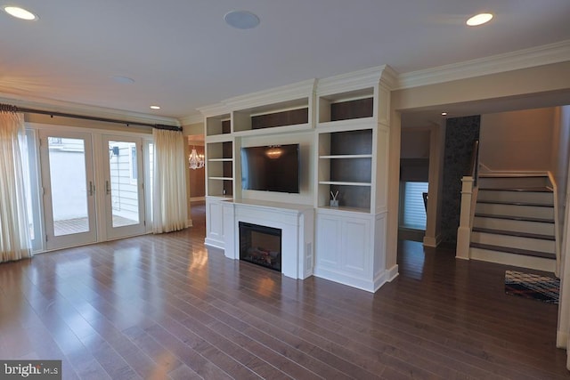 unfurnished living room featuring stairs, a glass covered fireplace, crown molding, and dark wood finished floors