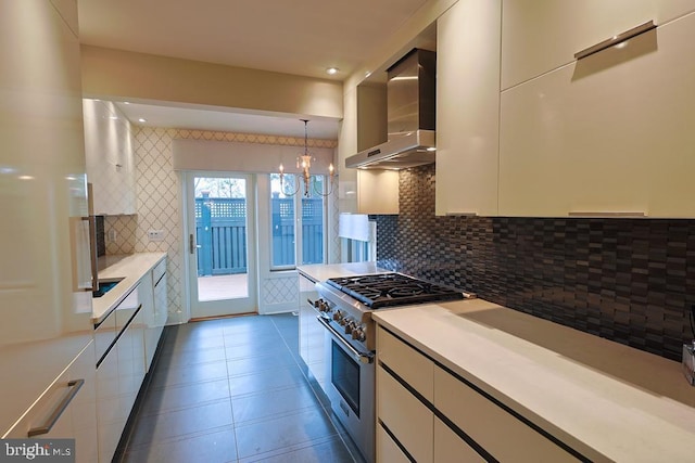 kitchen with stainless steel stove, white cabinets, light countertops, wall chimney exhaust hood, and modern cabinets