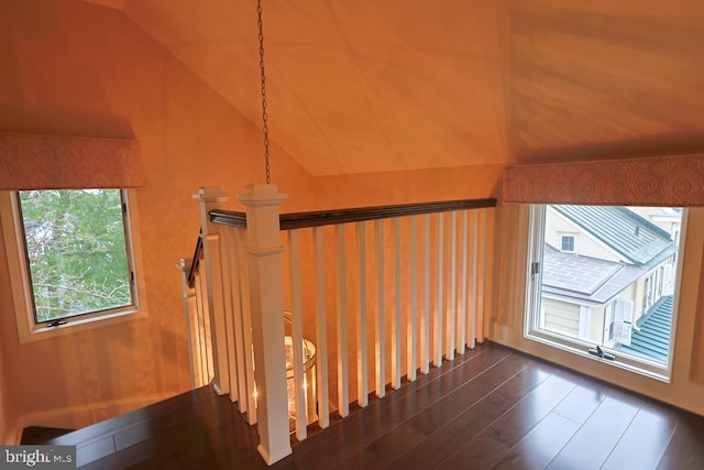 stairway with visible vents, lofted ceiling, and wood finished floors