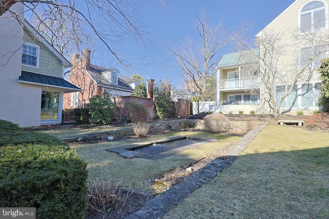 view of yard featuring a balcony and fence