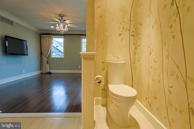 bathroom with visible vents, toilet, wood finished floors, crown molding, and baseboards