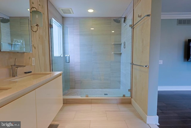 bathroom featuring double vanity, a stall shower, visible vents, and a sink