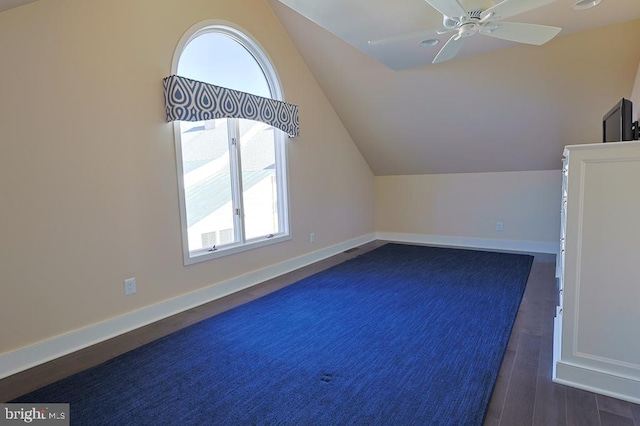 bonus room featuring a healthy amount of sunlight, dark wood-type flooring, baseboards, and vaulted ceiling