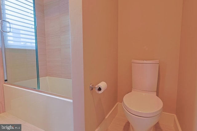 full bath with shower / bathing tub combination, toilet, and baseboards