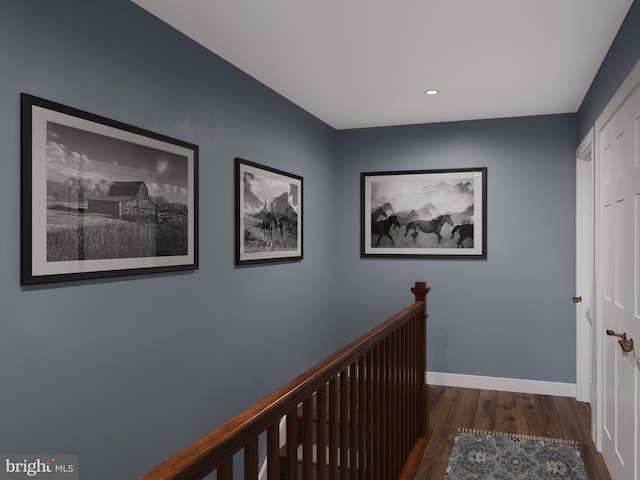 corridor featuring recessed lighting, baseboards, wood finished floors, and an upstairs landing