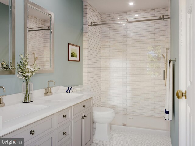 bathroom featuring toilet, a stall shower, and a sink