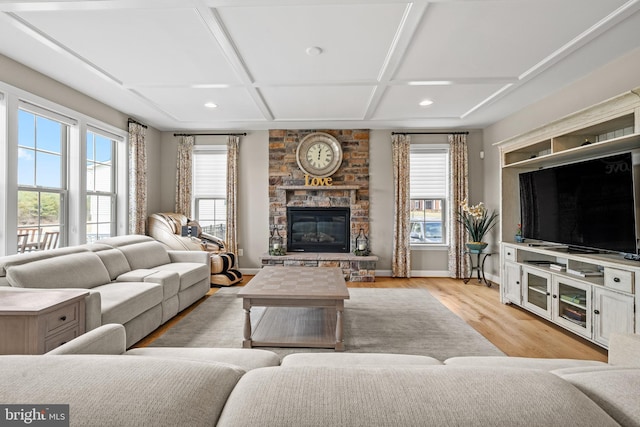 living area with baseboards, coffered ceiling, light wood-style flooring, and a fireplace