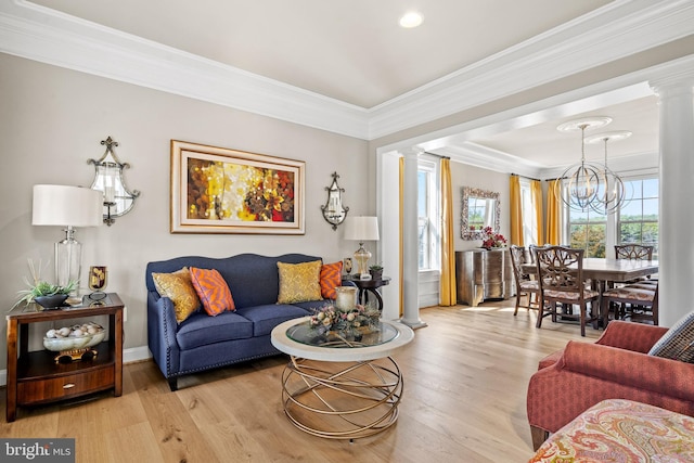 living area featuring light wood-type flooring, ornamental molding, and ornate columns