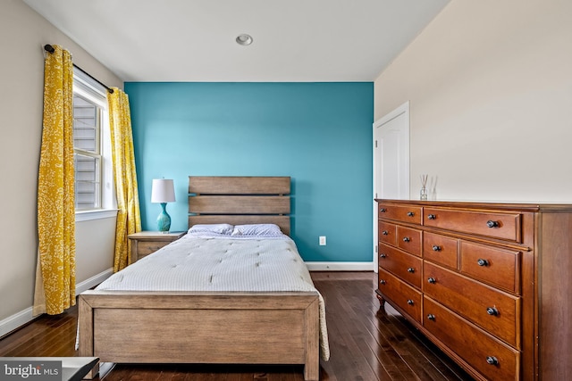 bedroom featuring baseboards and dark wood-style flooring